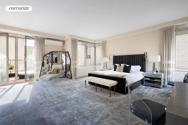 a spacious bedroom with a bed a couch and a large window