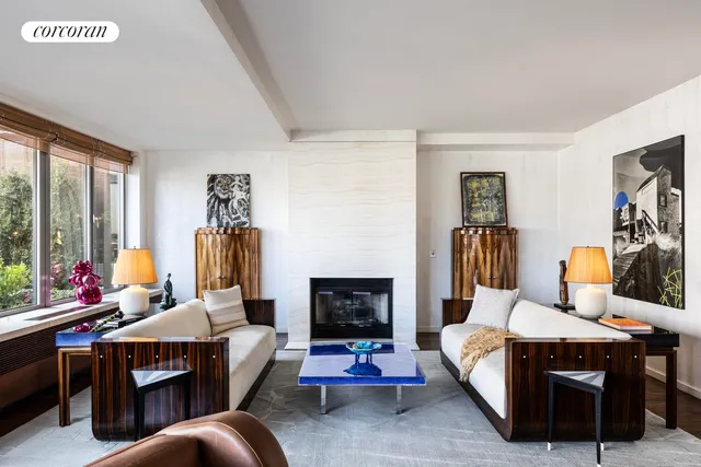 a living room with furniture fireplace and a large window