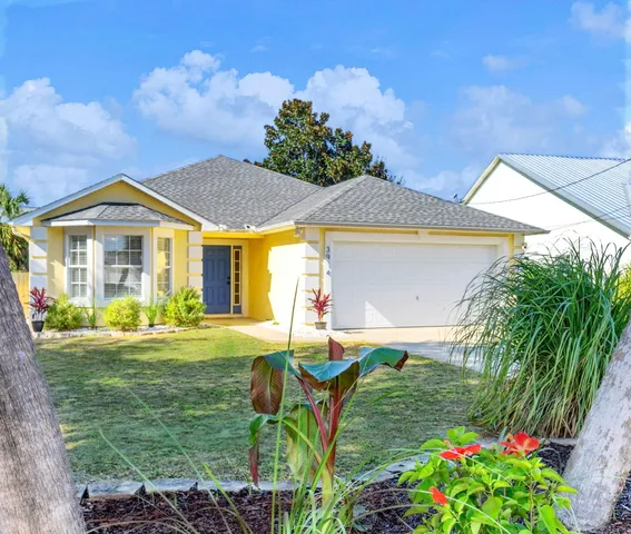 a front view of a house with a yard and trees