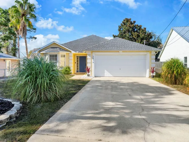 a view of a house with a yard and potted plants