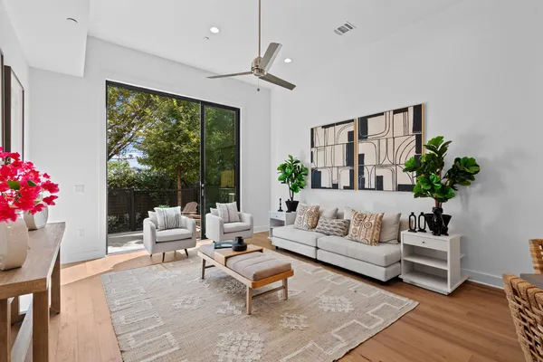 a living room with furniture potted plant and a large window