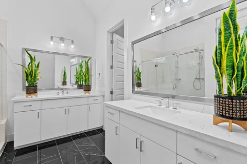 a bathroom with a double vanity sink and a large mirror
