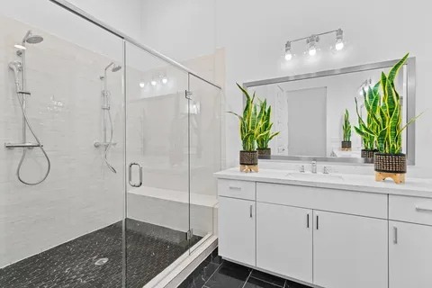 a bathroom with a granite countertop sink a mirror a shower and a mirror