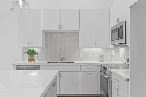 a kitchen with stainless steel appliances white cabinets and a sink