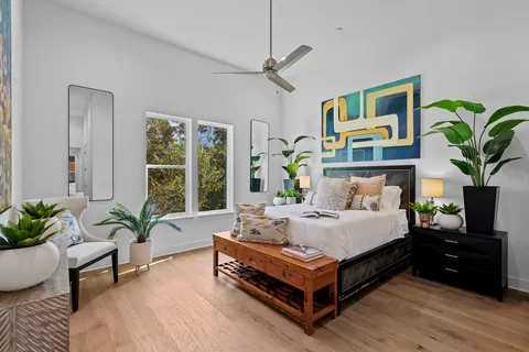 a bedroom with a bed couch and a potted plant