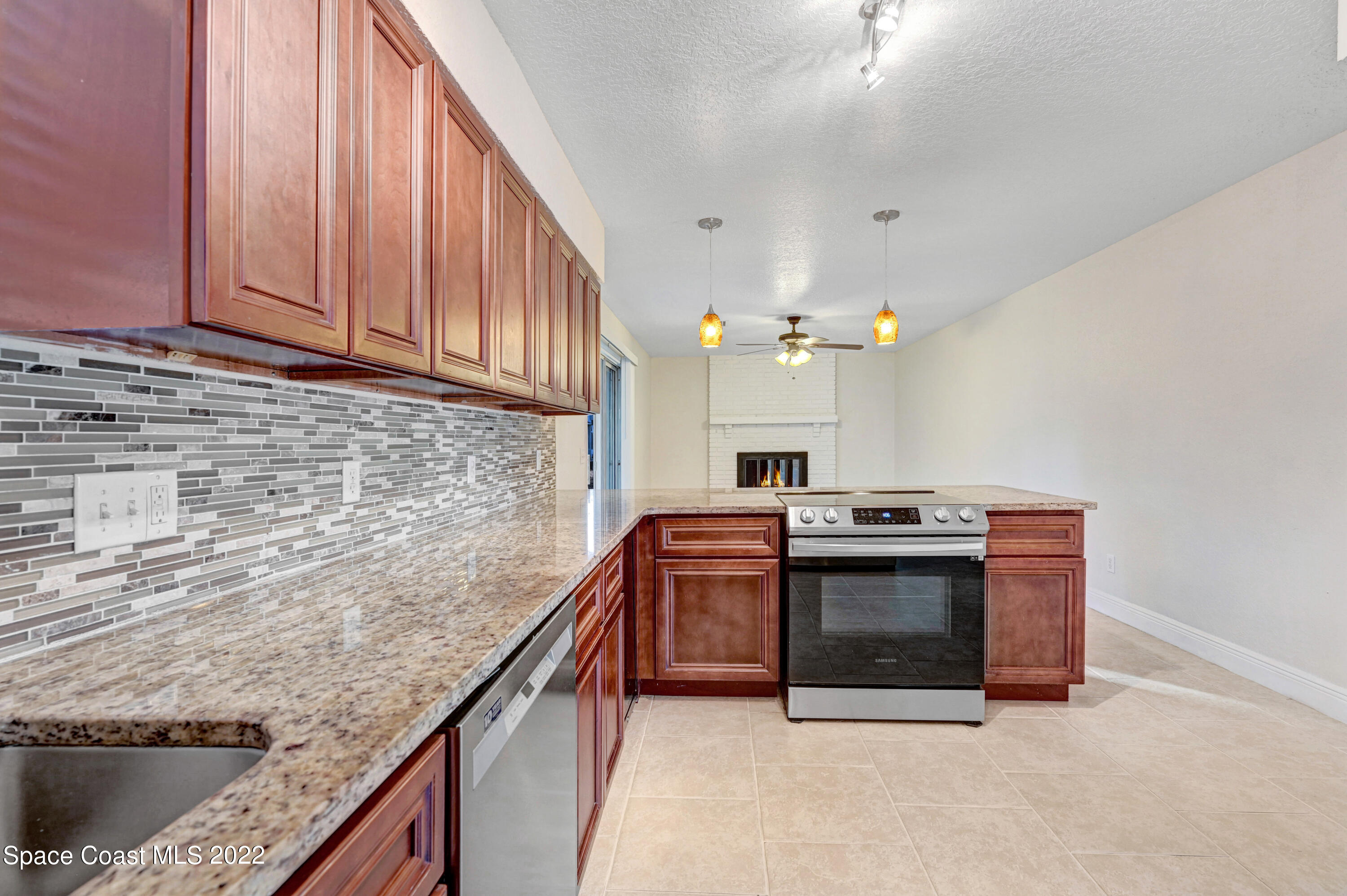1074 Castile Road Southeast Palm Bay, FL 32909 - Photo 11 of 40 a kitchen with stainless steel appliances granite countertop a stove a sink and a microwave