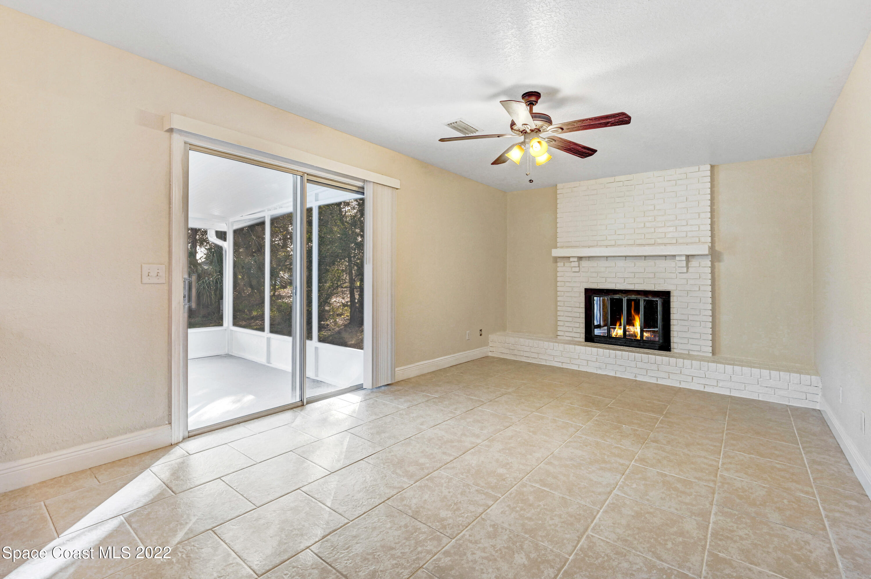 1074 Castile Road Southeast Palm Bay, FL 32909 - Photo 15 of 40 a view of an empty room with chandelier fan and a fireplace