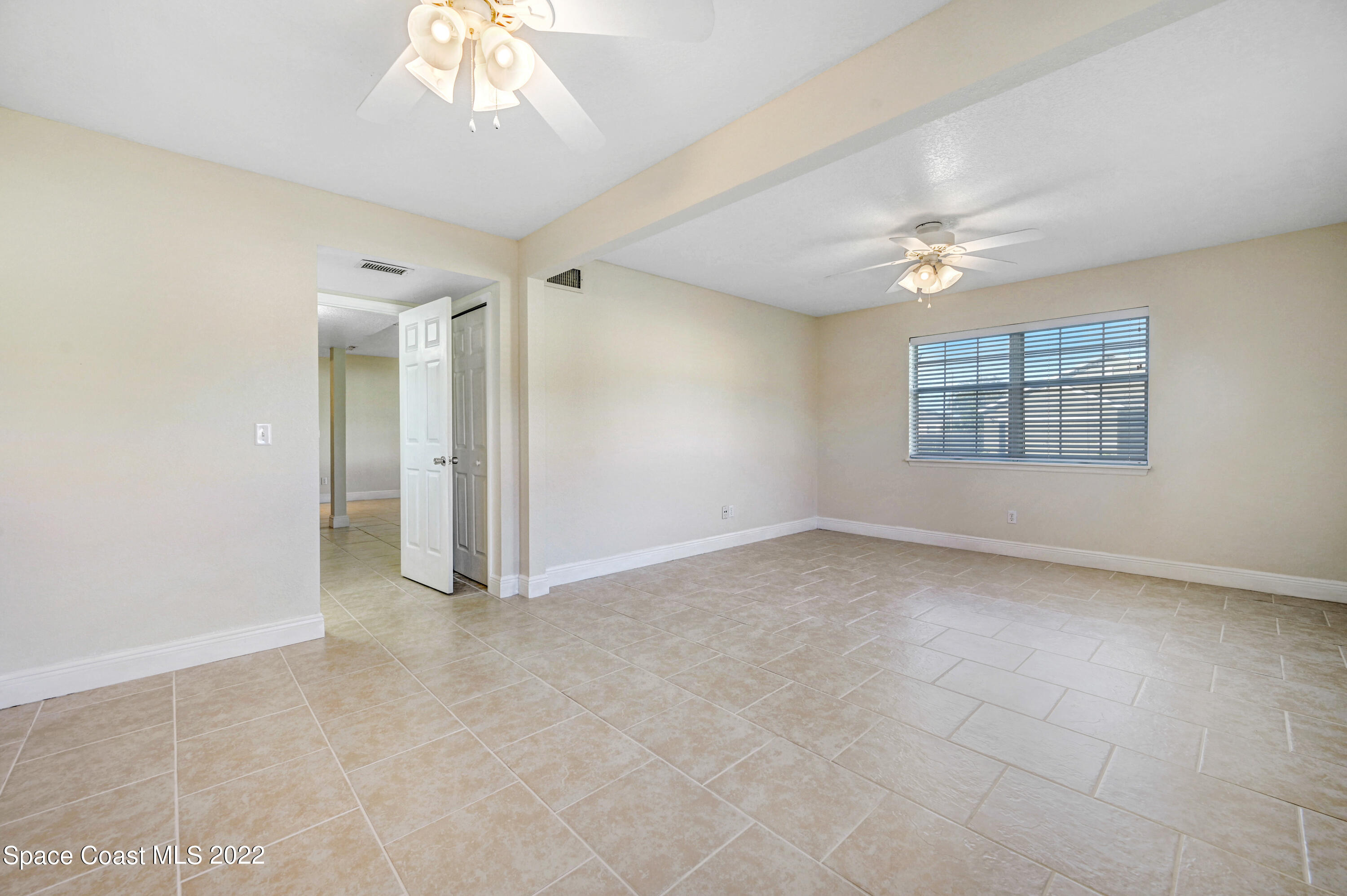 1074 Castile Road Southeast Palm Bay, FL 32909 - Photo 16 of 40 an empty room with windows and fan