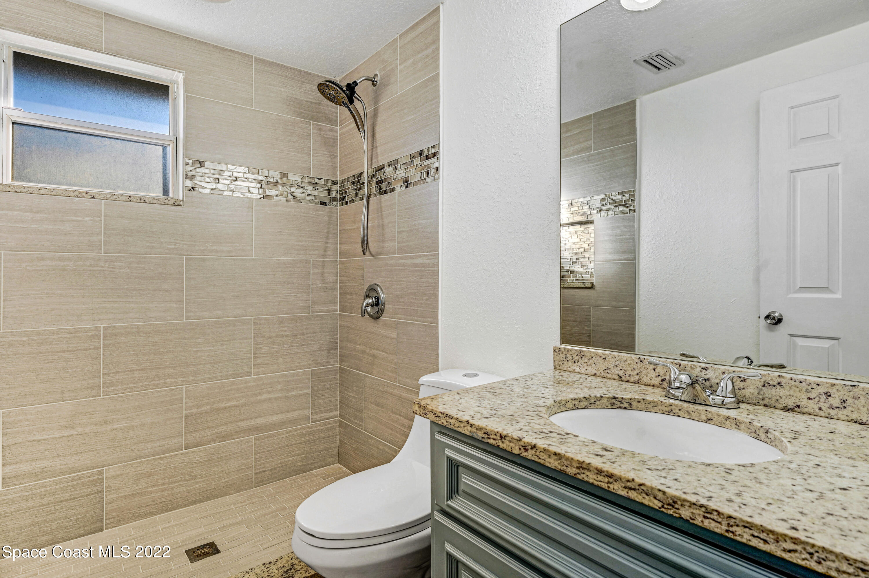 1074 Castile Road Southeast Palm Bay, FL 32909 - Photo 21 of 40 a bathroom with a granite countertop sink a toilet and shower