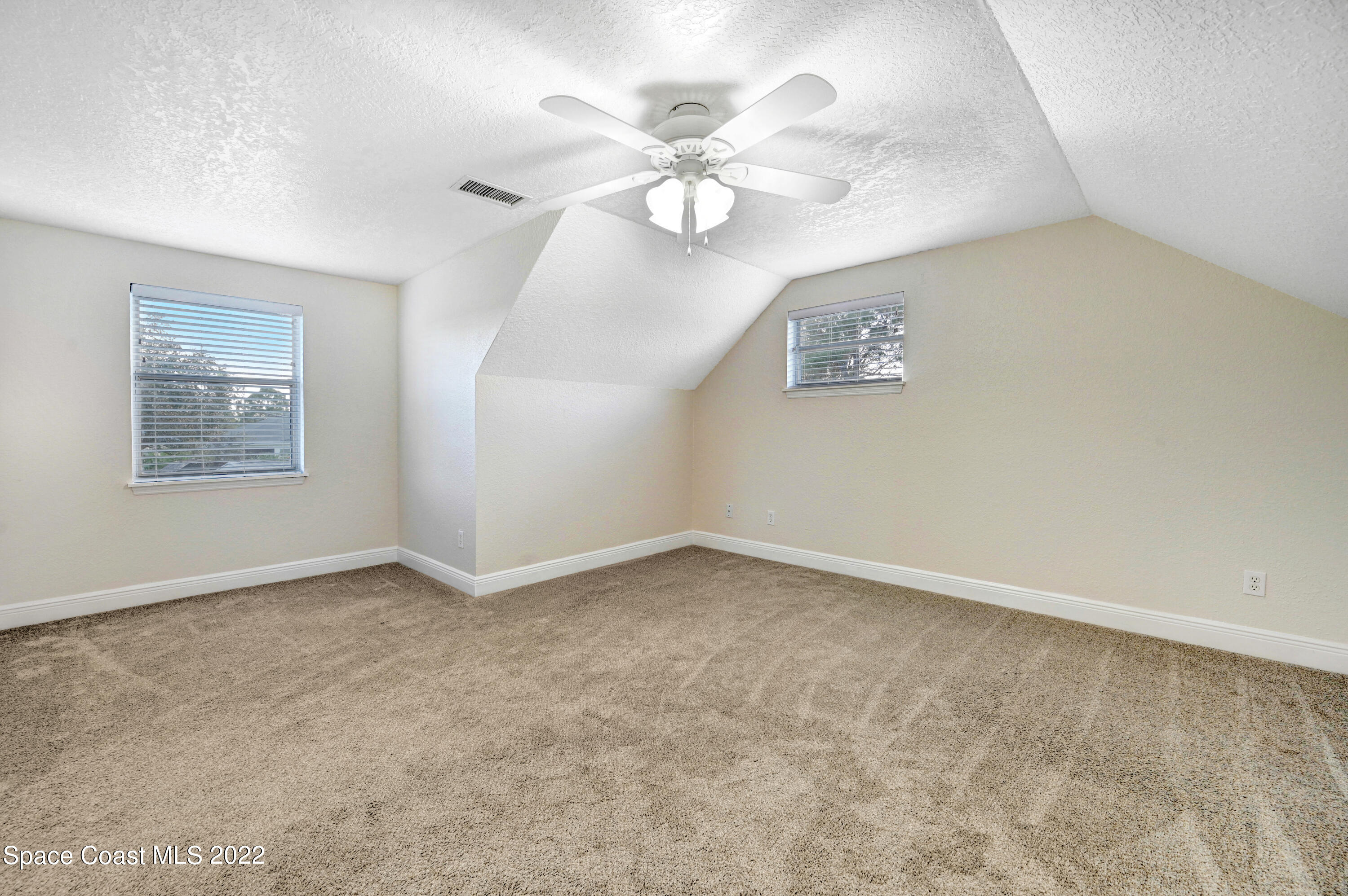 1074 Castile Road Southeast Palm Bay, FL 32909 - Photo 26 of 40 an empty room with windows and ceiling fan