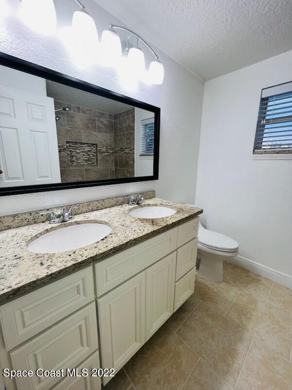 1074 Castile Road Southeast Palm Bay, FL 32909 - Photo 28 of 40 a bathroom with a granite countertop sink and a toilet