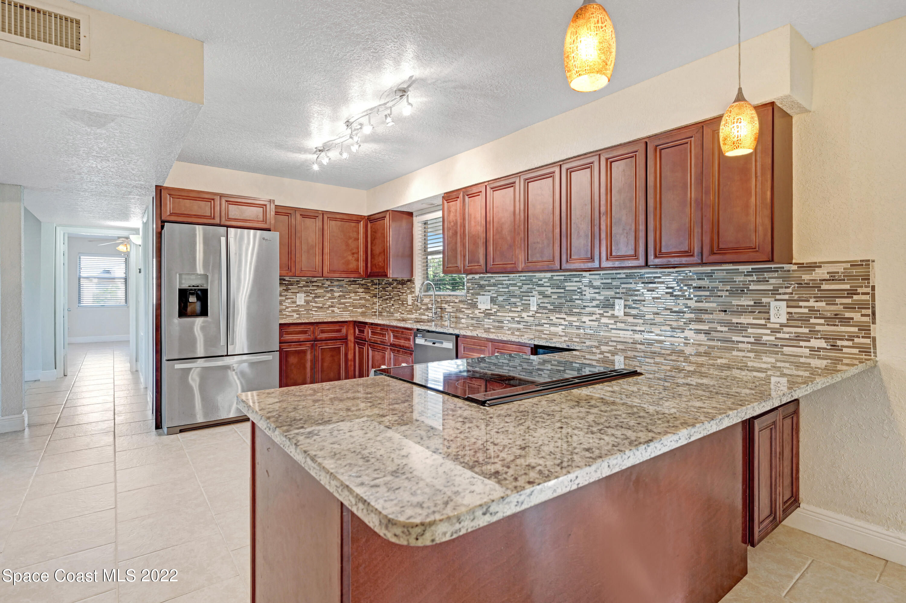 1074 Castile Road Southeast Palm Bay, FL 32909 - Photo 9 of 40 a kitchen with stainless steel appliances granite countertop a sink refrigerator and microwave