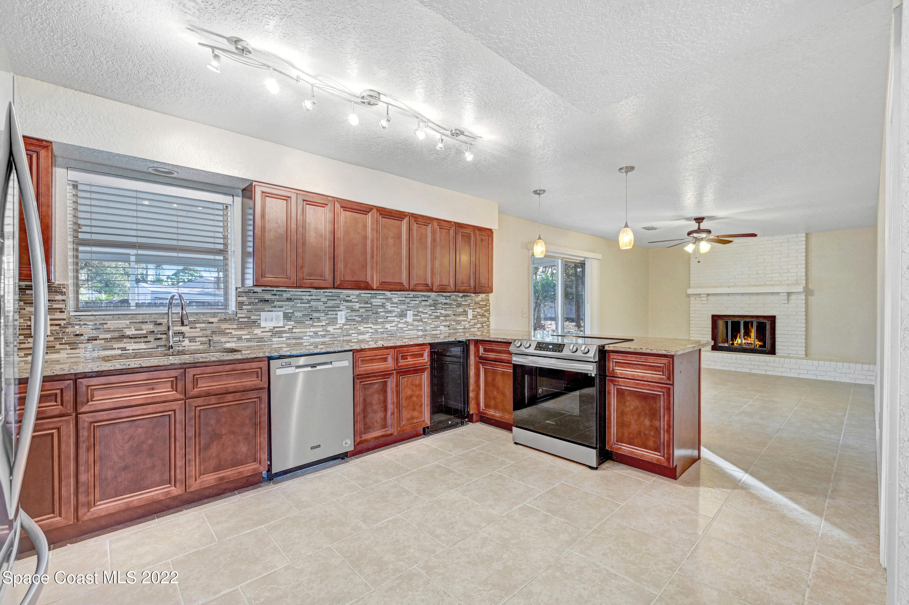 1074 Castile Road Southeast Palm Bay, FL 32909 - Photo 10 of 40 a kitchen with granite countertop a sink cabinets and window