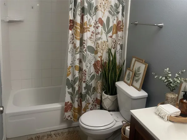 a white toilet sitting next to a bath tub