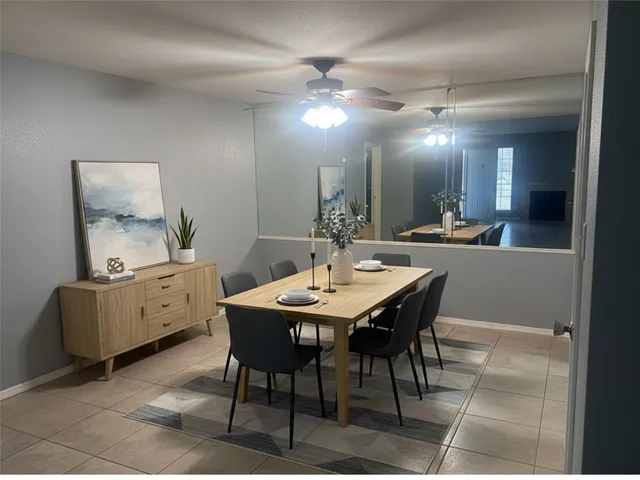 a dining room with a table chairs and a kitchen view