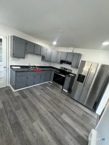 a kitchen with stainless steel appliances granite countertop a stove a sink and a refrigerator