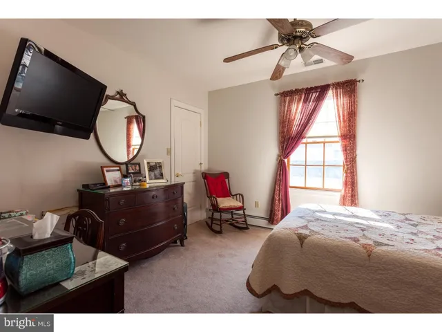 a living room with furniture a flat screen tv and a window