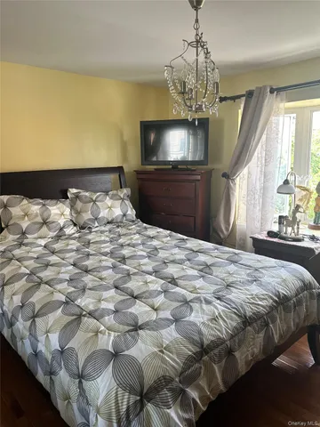 a bedroom with a bed and a chandelier