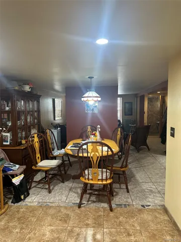 a living room with furniture a dining table and a chandelier
