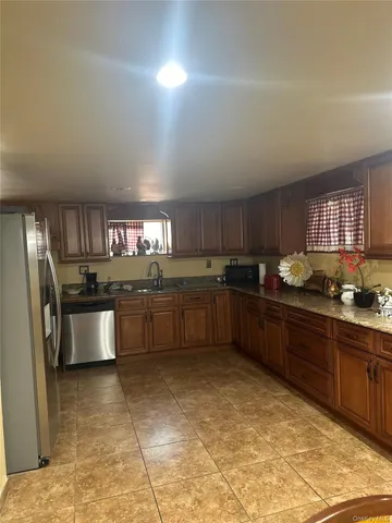 a kitchen with stainless steel appliances granite countertop a sink counter space cabinets and a large window