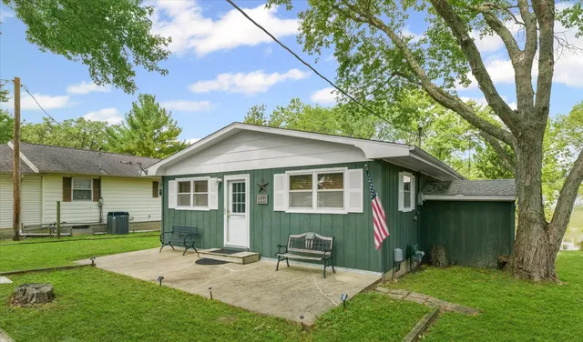 a view of a house with a yard and large tree