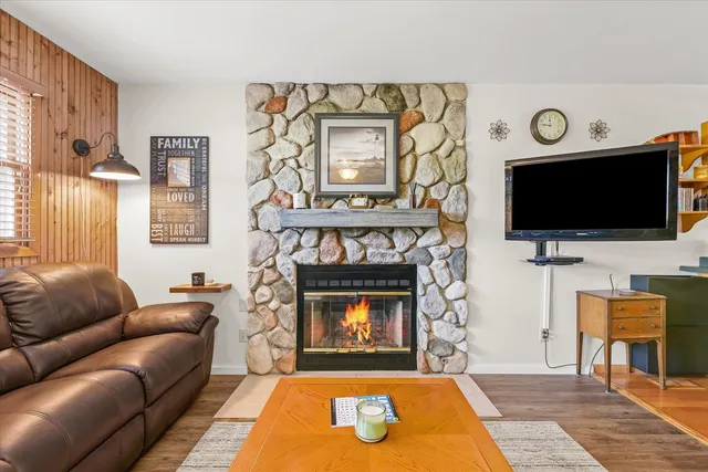 a living room with furniture a flat screen tv and a fireplace