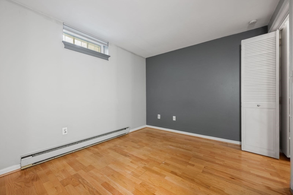 350 West Fourth Street, Unit 103 Boston, MA 02127 - Photo 16 of 33 an empty room with wooden floor and windows