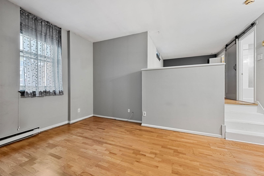 350 West Fourth Street, Unit 103 Boston, MA 02127 - Photo 9 of 33 a view of an empty room with wooden floor and a window
