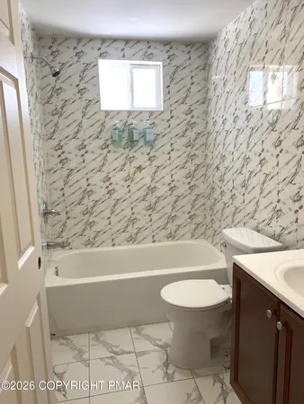 a bathroom with a toilet a sink and bathtub