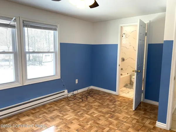 a view of a bedroom with a ceiling fan and a window