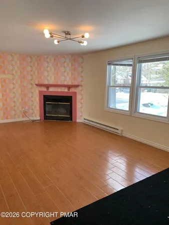 a view of an empty room with a fireplace and a window