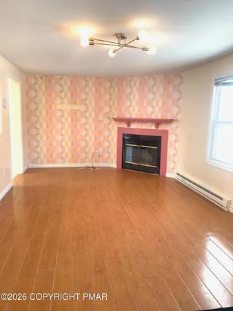 wooden floor fireplace and windows in an empty room