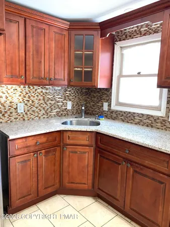 a kitchen with stainless steel appliances granite countertop wooden cabinets a sink and a window