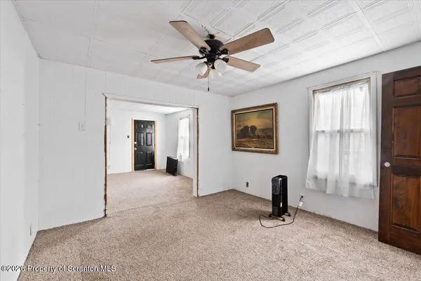 a view of a livingroom with a ceiling fan and window