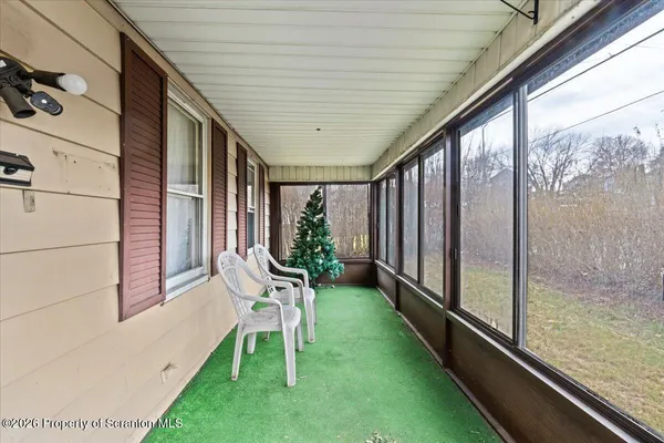 a porch with a bench next to yard
