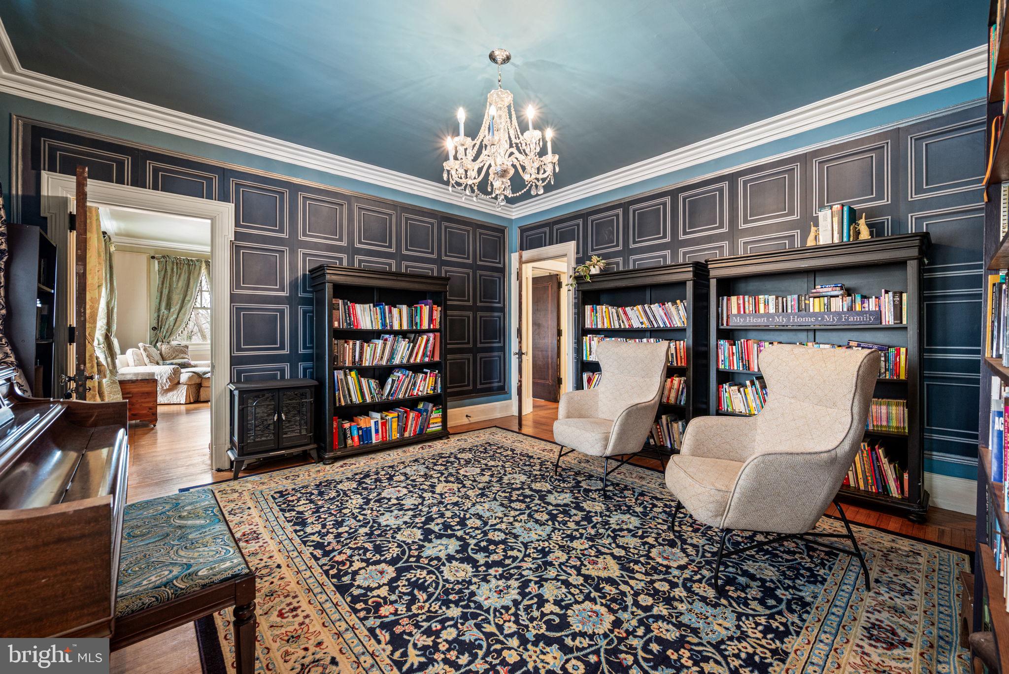 1018 Beech Road Wallingford, PA 19086 - Photo 29 of 66 a living room with fireplace furniture a chandelier and a bookshelf