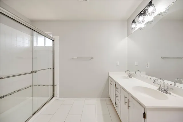 a spacious bathroom with a double vanity sink a mirror and a shower