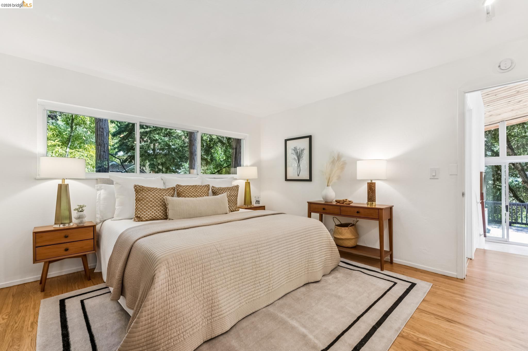 6645 Heather Ridge Way Oakland, CA 94611 - Photo 21 of 61 Bright bedroom featuring wood-finish flooring, a generous window expanse, and crisp white walls