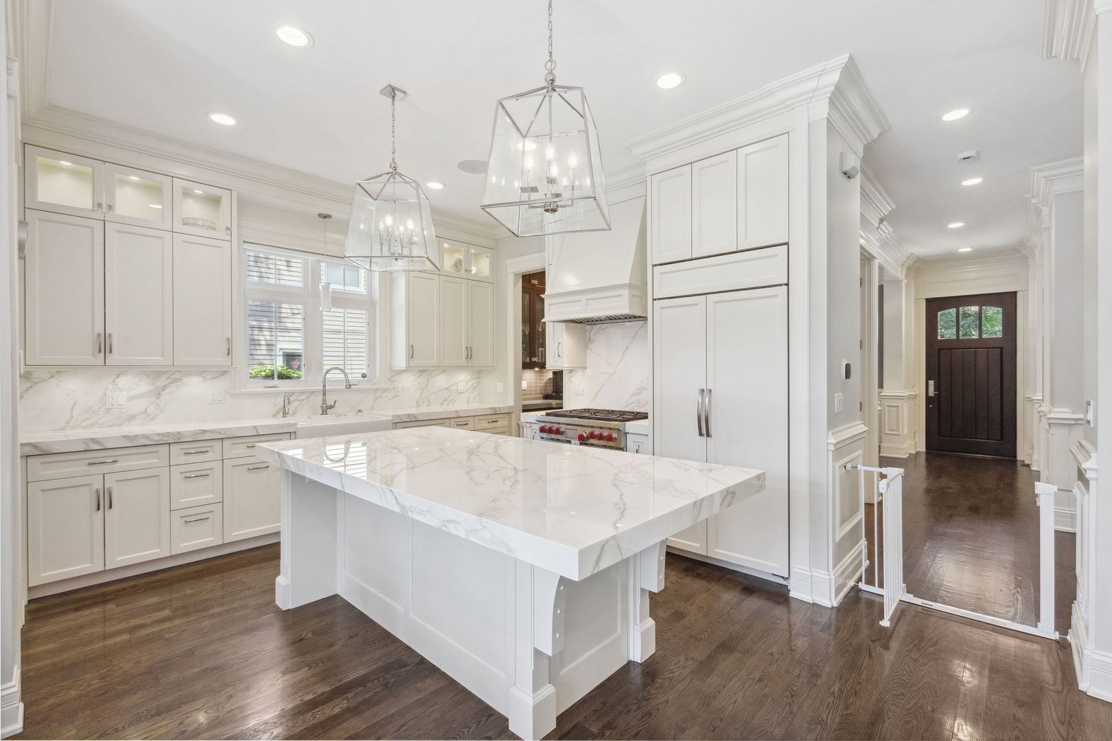 923 Harvard Lane Wilmette, IL 60091 - Photo 11 of 42 a large white kitchen with a large kitchen island white cabinetry and stainless steel appliances