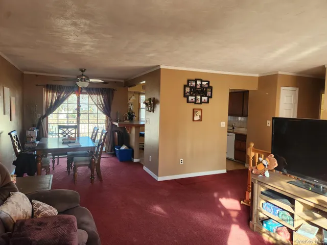a living room with furniture a flat screen tv and a large window