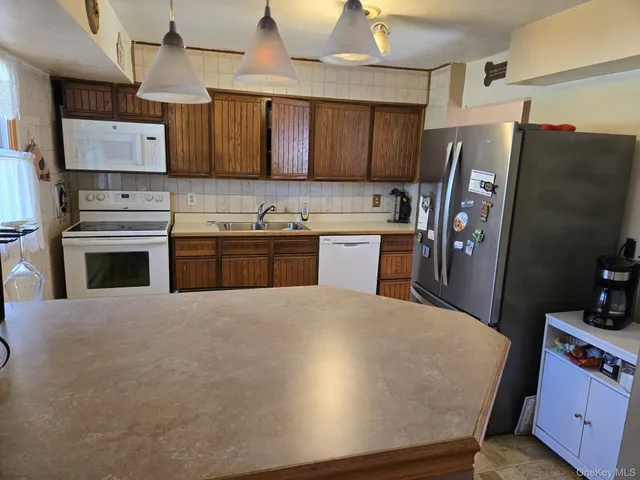 a kitchen with stainless steel appliances a refrigerator a sink a stove and cabinets