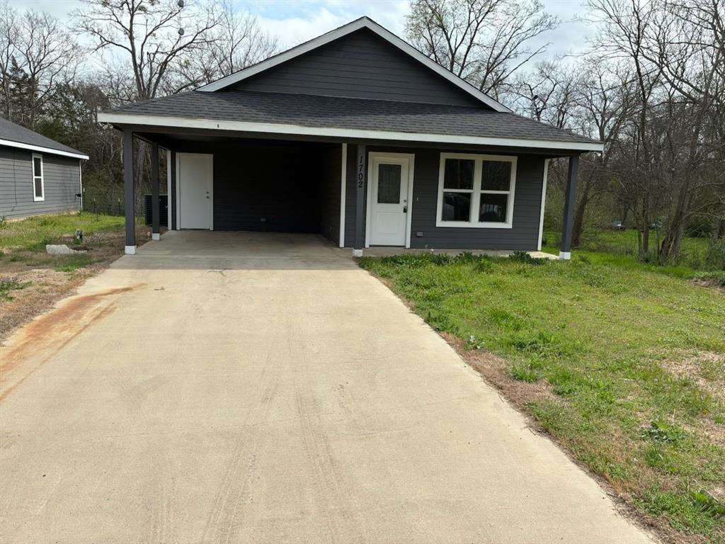 a front view of a house with a yard and trees