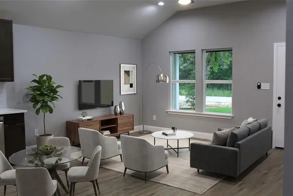 a living room with furniture a large window and a flat screen tv