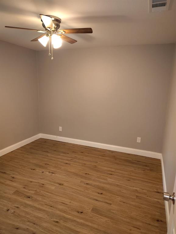 1702 Clark Street Commerce, TX 75428 - Photo 5 of 10 a view of an empty room with wooden floor