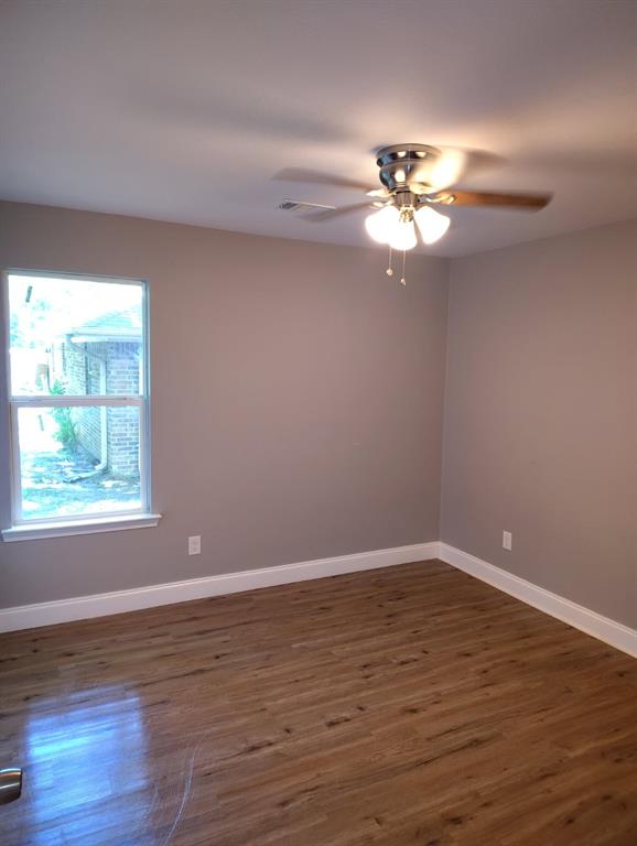 1702 Clark Street Commerce, TX 75428 - Photo 6 of 10 a view of an empty room with wooden floor and a window