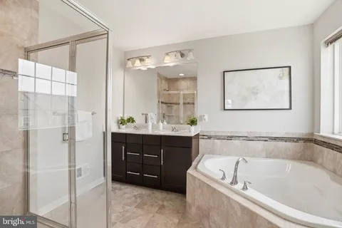 a bathroom with a tub a sink and mirrors