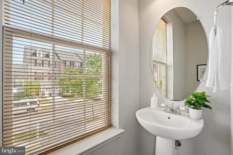 a bathroom with a sink a mirror and a window
