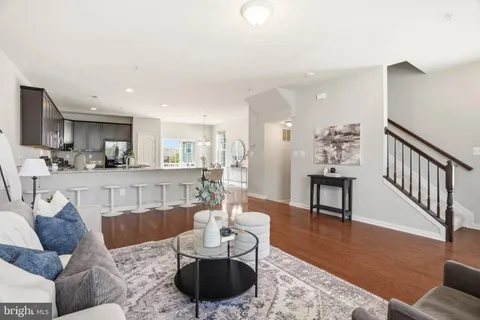 a living room with furniture and a dining table with kitchen view