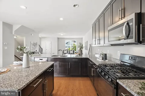 a kitchen with stainless steel appliances granite countertop a sink stove and microwave