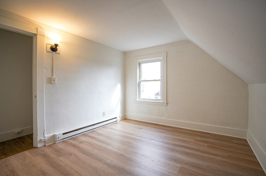 83-85 Wilmont Street, Unit 3 Springfield, MA 01108 - Photo 11 of 12 an empty room with wooden floor and windows